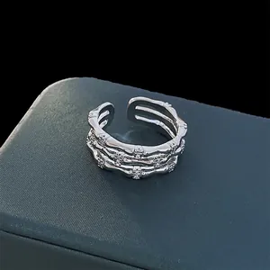 Close-up view of a silver multi-layer open ring with zircon stones in a textured bamboo design