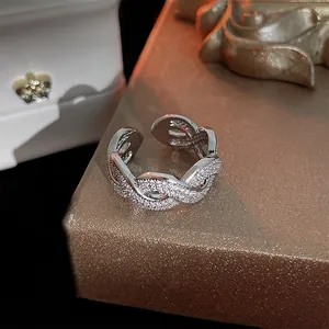 Macro view of silver-tone twisted open ring paved with sparkling cubic zirconia