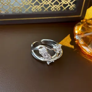 Detailed view of a geometric silver-plated open ring with baguette cubic zirconia stones.