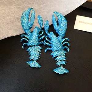 Detailansicht der blau lackierten Hummer-Ohrringe mit beweglichem Anhänger.
