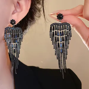 Close-up of elegant black heart-shaped zircon tassel drop earrings for evening wear