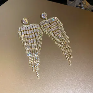 Detailed view of luxury gold tassel earrings with shimmering baguette zircon stones.