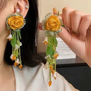 Forest style yellow rose tassel earrings with white bell flowers and green beads.