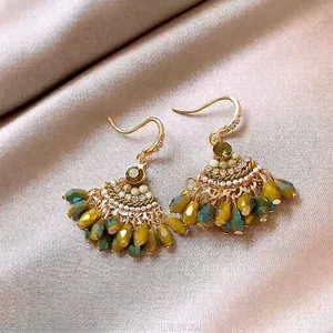 Close-up detail view of Bohemian fan-shaped crystal tassel hook earrings in green finish