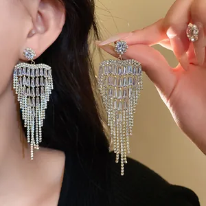 Detail view of elegant heart-shaped zircon tassel earrings shown on a model's ear