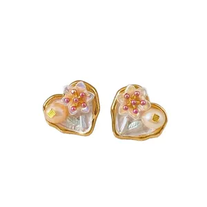 Elegant vintage heart-shaped earrings featuring flower and pearl on white background