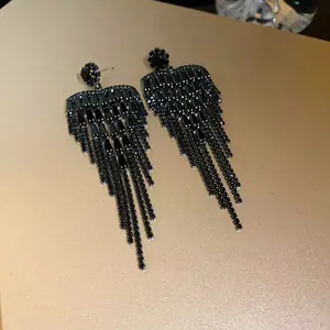 Close-up of elegant black zircon heart tassel earrings with shimmering fringes