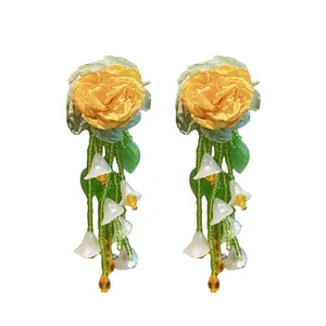 Elegant yellow flower tassel earrings with silver needles and green leaf accents