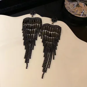 Detail of elegant black heart-shaped zircon tassel earrings for evening gowns.