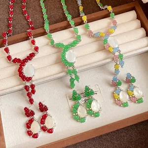 Pantalla detallada de juegos de joyas de resina de colores con collares y pendientes a juego.