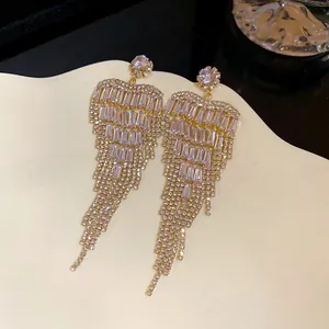 Close-up of sparkling heart-shaped tassel earrings featuring brilliant cubic zirconia details.