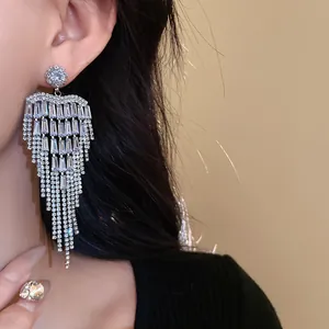 Close-up of sparkling zircon heart tassel earrings worn for evening dress style.