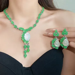 Elegante conjunto de collar y pendientes de resina verde con piedra central nacarada.