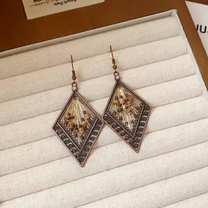 Macro detail of bohemian geometric earrings with vintage bronze finish and beads