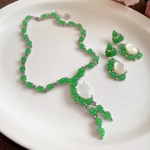 Detalle del conjunto de collar y pendientes de capullos verdes de resina y piedras