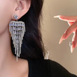 Detailed macro view of sparkling zircon tassel earrings on an Asian model's ear