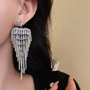 Macro detail of elegant silver needle zircon tassel earrings worn by an Asian model