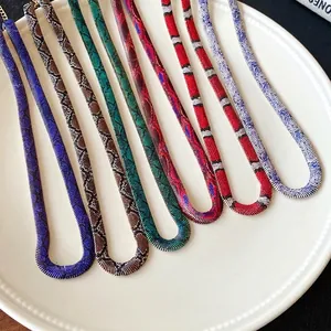 Surtido de collares planos de colores con estampado de serpiente presentados en un plato blanco