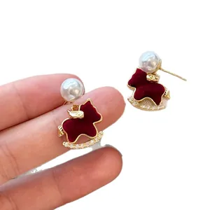 Elegantes pendientes de caballito de madera rojo flocado con perla y cristales brillantes.