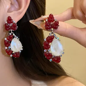 Elegantes pendientes colgantes de resina roja con forma de capullo y piedra nacarada