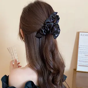 Vista dettagliata di un'elegante pinza per capelli in tessuto nero a pieghe su capelli