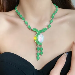Primer plano de collar de resina verde con piedra opalescente en modelo
