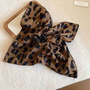 Primer plano de una pinza para el pelo vintage de tela con estampado de leopardo en madera