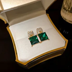 Luxury vintage green square crystal stud earrings presented in a golden jewelry box