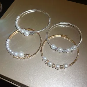 Macro view of elegant baroque style open bangles featuring pearls and shiny rhinestones