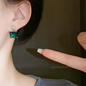 Close-up of vintage emerald green geometric crystal earring with pavé diamond detail