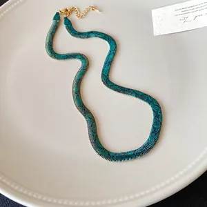 Primer plano de un collar plano con estampado de serpiente retro en un plato blanco.