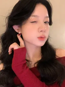 Primer plano de pendiente de poni flocado rojo con perla y diamantes de imitación