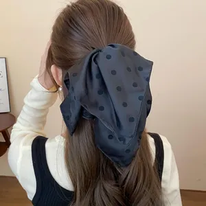 Primer plano detallado de un lazo para el cabello negro con lunares en el cabello castaño