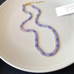 Collar con estampado de serpiente azul y blanco en un plato de cerámica blanca
