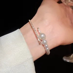 Close-up of elegant baroque pearl and diamond open cuff bracelet on wrist