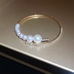 Detailed view of elegant baroque open bracelet with sparkling crystals and graduated pearls