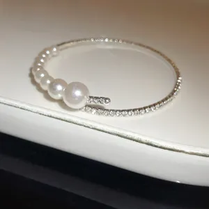 Detailed macro view of elegant Baroque pearl and pavé rhinestone open-ended bangle