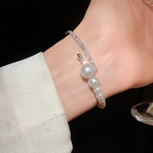 Detailed view of an elegant baroque style open bangle with pearls and sparkling diamonds.