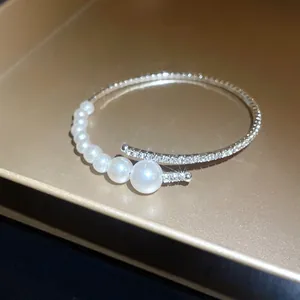 Detail view of an elegant baroque pearl open bangle with sparkling rhinestone accents