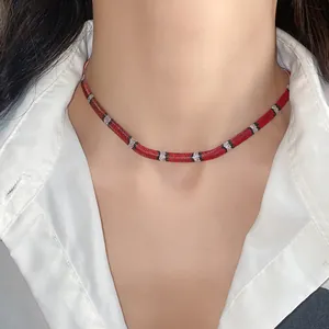 Vista detallada de un collar tipo gargantilla con motivo de serpiente en rojo y negro.