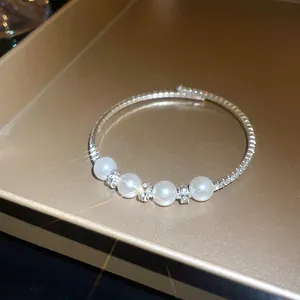 Macro view of French retro bangle with lustrous pearls and sparkling rhinestones