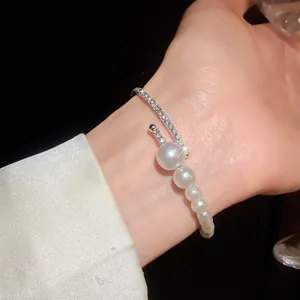 Detailed close-up of a French retro pearl and rhinestone open cuff bracelet on wrist