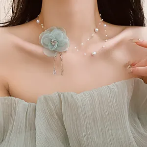 Detailed close-up of a mesh flower necklace with pearls and teardrop zircon on neck