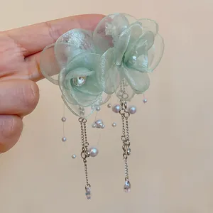 Detail view of a light green mesh flower necklace with delicate pearls and zircon drops.