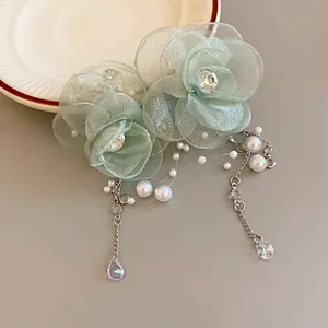 Close-up detail of elegant mesh flower necklace with pearls and zircon teardrop pendants