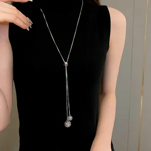 Close-up detail of an adjustable silver stainless steel long Y-necklace with spheres