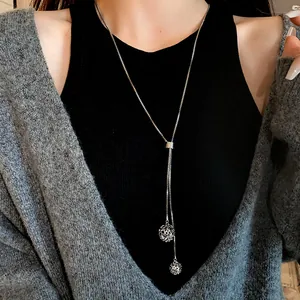 Elegant adjustable stainless steel long necklace with hollow ball pendants on model.