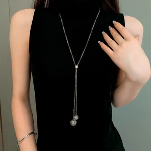 Close-up detail of adjustable stainless steel sweater chain with hollow ball pendants