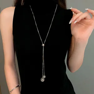 Detail of adjustable stainless steel long Y-necklace with delicate hollow ball pendants