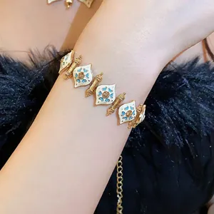 Exquisite vintage gold bracelet with white and blue enamel details shown on wrist